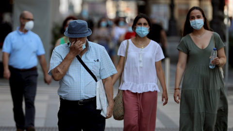 29/07/2020.- Varios ciudadanos con mascarilla pasean por una calle del centro de Madrid, este miércoles. La Comunidad de Madrid declaró obligatorio el uso de mascarilla en todos los espacios, abiertos o cerrados, no permitirá grupos de más de diez per