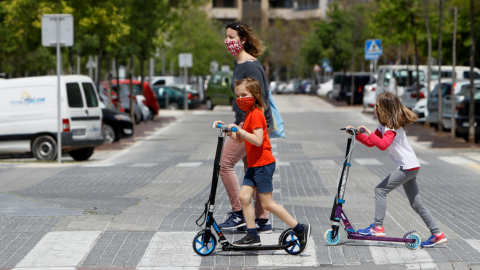 Dos niñas con mascarillas el primer día en el que los menores de 14 años pueden salir a la calle durante el estado de alarma. Europa press / Isaac Buj