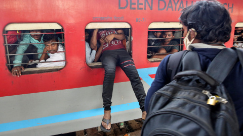 Un trabajador migrante intenta coger el tren en Mumbai, India. REUTERS / Prashant Waydande