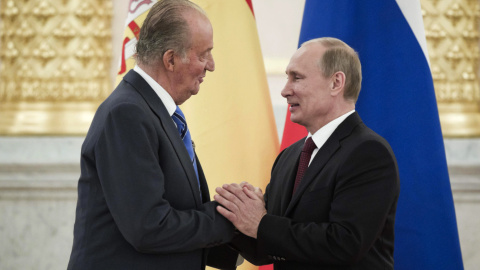  El rey emérito de España, Juan Carlos I, y el presidente de Rusia, Vladímir Putin (i), se saludan en un momento de la ceremonia oficial celebrada en 2012 en la que el monarca recibió el Premio Estatal de Rusia, máximo galardón que concede este paí