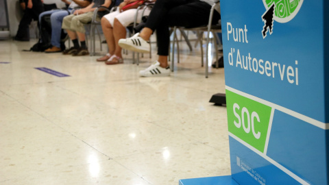 Imatge d'una sala interior d'una oficina del Servei d'Ocupació de Catalunya (SOC) on es veuen els peus d'uns aturats asseguts a la sala d'espera. ANDREA ZAMORANO / ACN