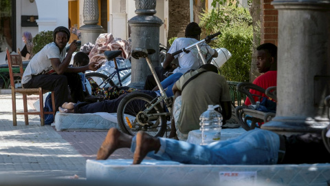 Un grupo de trabajadores migrantes en la plaza de España de Lepe (Huelva), donde protestan para que el Ayuntamiento dé una solución tras varios incendios en sus asentamientos de chabolas.- EFE/ Julián Pérez