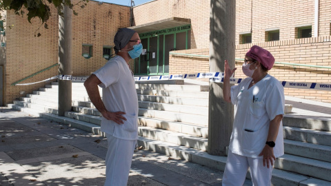 Dos sanitarios conversan en las inmediaciones del polideportivo Cortes de Aragón de Fraga, Huesca este martes | EFE