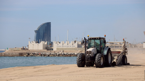 Un tractor en la represa del servei de neteja de les platges a Barcelona, a la platja del Bogatell, el 7 de maig del 2020. (Horitzontal)