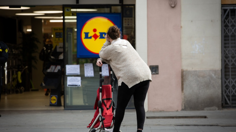 Una mujer espera con su carro de la compra a poder entrar a un supermercado Lidl , en Barcelona. E.P./David Zorrakino