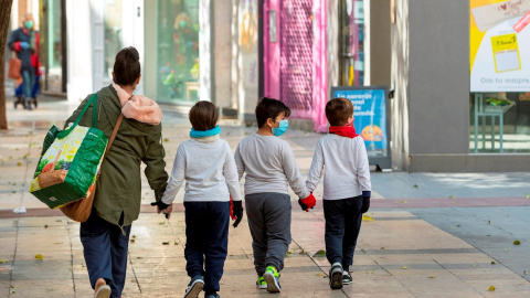 Fotografía de archivo de una madre y sus hijos tras hacer la compra en Zaragoza. EFE/ JAVIER BELVER/Archivo