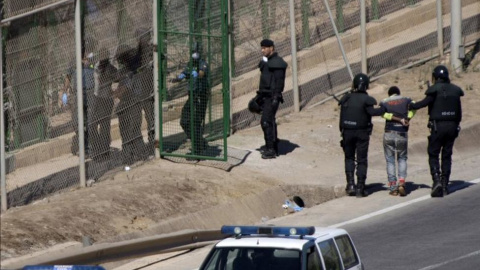 Una de las devoluciones en caliente en la valla de Melilla por las que Estrasburgo ha condenado a España, el 13 de agosto de 2014.- EFE