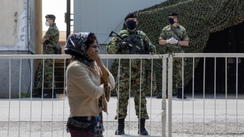 Una mujer migrante pasa junto a un control militar.  -REUTERS/Marko Djurica