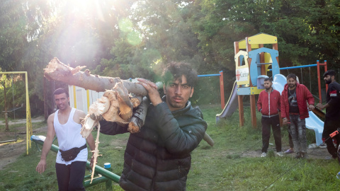 Un migrante transporta leña en el campamento de Principovac para migrantes cerca de Sid, Serbia. - REUTERS / Marko Djurica