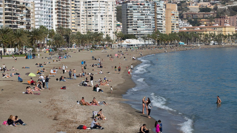 Varias personas toman el sol en la playa de La Malagueta. EFE