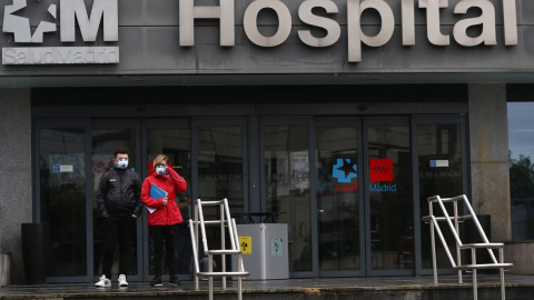 Dos personas con mascarilla, en el exterior de un hospital en Madrid. REUTERS