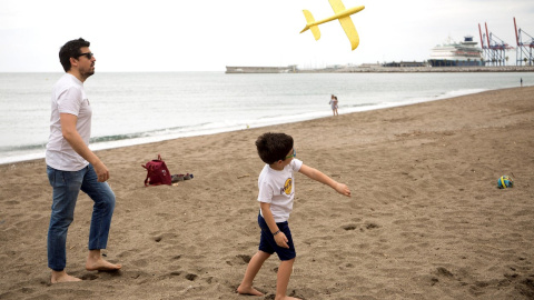 26/04/2020.- Un niño junto a su padre en la Playa de la Malagueta este domingo, cuadragésimo tercer día de estado de alarma, cuando más de seis millones de niños de hasta 14 años han podido salir por primera vez a la calle desde el inicio del confin