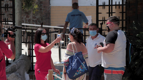 Una trabajadora mide la temperatura de los visitantes al Parque Marítimo del Mediterráneo en Ceuta. EFE/ Reduan Dris