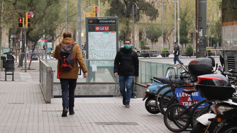 Una persona amb mascareta sortint de la boca de metro de plaça Universitat en plena onada de coronavirus a Barcelona. AINA MARTÍ / ACN