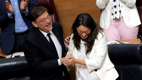 12/06/2019.- El candidato a la reelección como president de la Generalitat, Ximo Puig, y la vicepresidenta en funciones, Mónica Oltra, se dan la mano tras su discurso de investidura en Les Corts Valencianes. EFE/Manuel Bruque