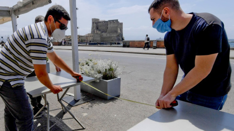 19/05 / 2020.- Los miembros del personal organizan de un establecimiento en el paseo marítimo de Caracciolo en Nápoles, Italia. / EFE - CIRO FUSCO