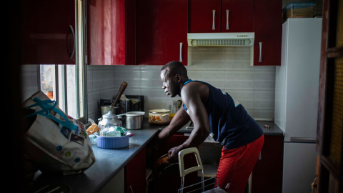 Serigne, en la cocina de su piso de Lavapiés, que comparte con otros cuatro compañeros, con el rostro pixelado por petición expresa.- JAIRO VARGAS