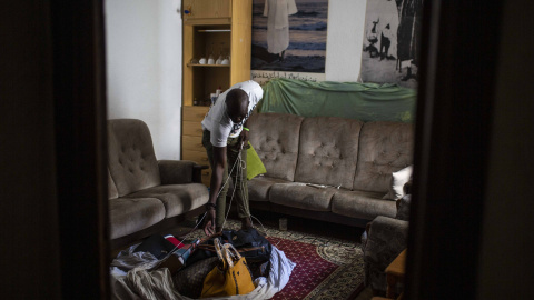 Samba, senegalés de 28 años, muestra el el salón de su casa de Lavapiés la manta con los bolsos que no ha podido vender en la calle durante el confinamiento decretado por el coronavirus.-  JAIRO VARGAS