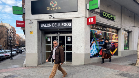 Pie de Foto: Dos personas pasan junto a un salón de juegos de Madrid el mismo día en el que se ha anunciado que el control físico de acceso a casas de apuestas será obligatorio en los 678 locales de la Comunidad de Madrid, en Madrid (España) a 18 de 