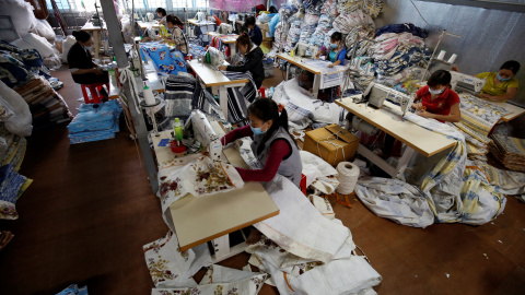 Un grupo de mujeres  trabaja en una fábrica privada que produce mantas fuera de Hanoi, Vietnam.REUTERS / Kham