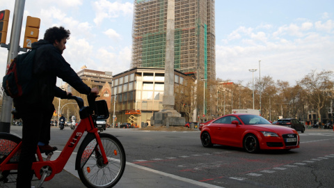 Un home espera creuar en bicicleta el pas de vianants, a tocar de la plaça Cinc d'Oros de Barcelona. ACN/Blanca Blay