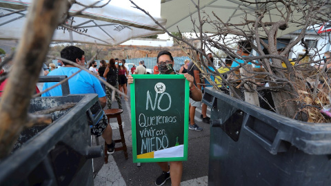 Una manifestante con un cartel que pone: "No queremos vivir con miedo" durante la protesta en Tunte por el traslado a su antigua residencia escolar a un grupo de inmigrantes en cuarentena. EFE/Elvira Urquijo A.