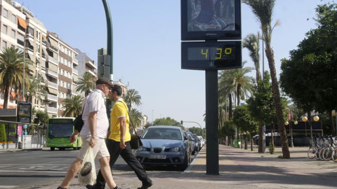 Dos personas pasan junto a un termómetro en Córdoba. - EFE