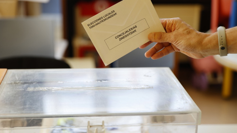  Personal con un sobre y una urna electoral en un colegio electoral de Bilbao, donde este domingo se vota a los municipios y a las diputaciones en el País Vasco. — EFE/Luis Tejido