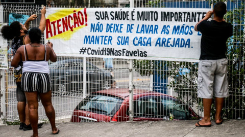 Las entradas principales del Complexo do Alemão (Río de Janeiro), uno de los complejos de favelas más grandes de Brasil, cuentan con pancartas de aviso a los vecinos. COLETIVO PAPO RETO.