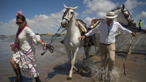  Los peregrinos cruzan el río Guadalquivir en ruta hacia el santuario de El Rocío en el parque nacional de Doñana durante la peregrinación anual de El Rocío.- AFP