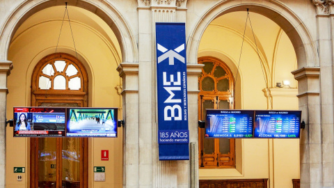 El logo de BME entre dos monitores de información en el patio de negociación de la Bolsa de Madrid. E.P.