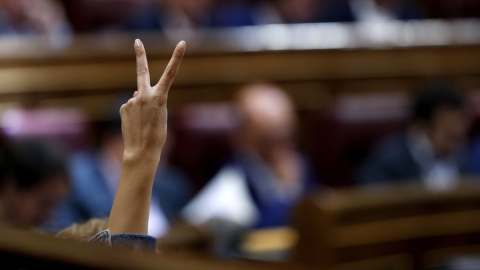 Una diputada socialista indica con los dedos levantados el sentido de la votación durante la última jornada de debate en el Pleno del Congreso de los Presupuestos Generales del Estado de 2017. EFE/Chema Moya