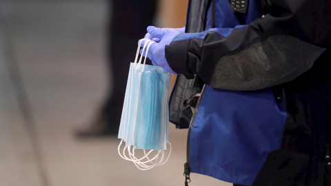 16/04/2020 Un policía hace entrega a los usuarios del transporte público de mascarillas en la estación de Cercanías de Atocha, Madrid. / EFE - JUANJO MARTÍN