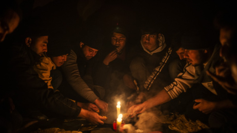 Migrantes afganos cenan en el interior de un edificio abandonado donde están viviendo en Bihac. JM López.