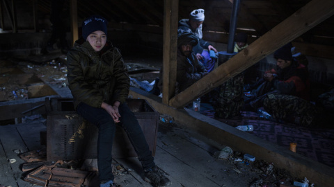 Ehsan, de 11 años, espera el momento de partir hacia la frontera con Croacia en el interior de una cabaña junto con sus compatriotas afganos. JM López.