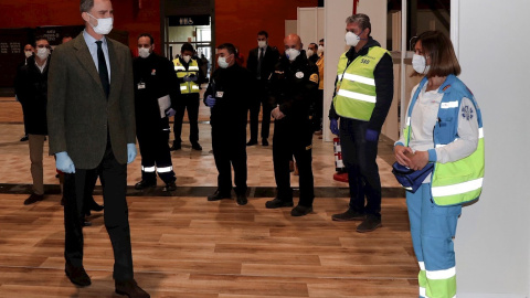 Felipe VI, con mascarilla y guantes como medida de prevención, ha visitado este jueves el hospital de emergencia instalado en el recinto ferial de Ifema de Madrid. /EFE