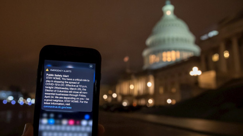 Un mensaje para quedarse en casa llega a un móvil de la ciudad de Washington a las puertas del Capitolio. /EFE