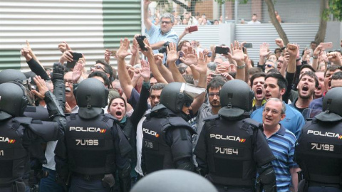 Agentes de la policía nacional forman un cordón policial en el exterior del IES Tarragona. Las cargas policiales ante los colegios electorales y el insólito modo de votación están marcando la jornada del 1-O en Catalunya. EFE/Jaume Sellart