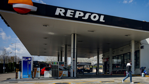 Un joven con máscarilla pasa por delante de una estación de servicio de Repsol en Madrid. E.P.