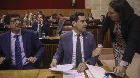 Juanma Moreno, junto a Juan Marín, atiende a Loles López, hoy en el Parlamento. Europa Press