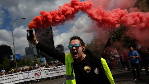 Un conductor de taxi sostiene una bengala durante la protesta contra las empresas de economía colaborativa como Uber, a las que acusan de 'dumping', este miércoles en Madrid. REUTERS/Susana Vera