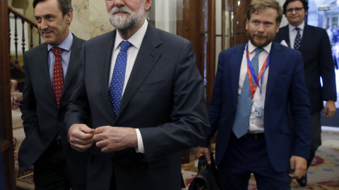 El presidente del Gobierno, Mariano Rajoy (c), acompañado del portavoz del PP, Rafael Hernando (i), tras la aprobación  del proyecto de Presupuestos para 2017. EFE/Kiko Huesca