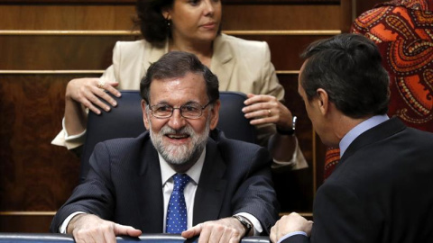 El presidente del Gobierno, Mariano Rajoy,c., el portavoz del Grupo Parlamentario Popular, Rafael Hernando,d., y la vicepresidenta del Gobierno, Soraya Saénz de Santamaría, detrás, durante la última jornada de debate y votación en el Congreso de los 