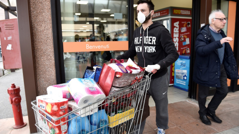 Un hombre hace acopio de productos ante el posible aislamiento en el norte de Italia. REUTERS/Flavio Lo Scalzo