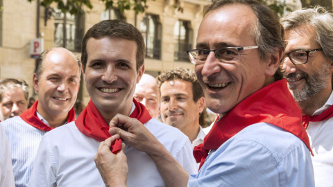 El presidente del PP del País Vasco, Alfonso Alonso, pone al presidente de los populares, Pablo Casado, el pañuelo festivo durante la visita de ésta a Vitoria. EFE