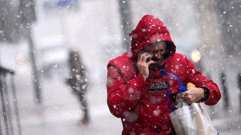 Un hombre camina por una calle de Reinosa, este lunes en la comunidad cántabra donde la Agencia Estatal de Meteorología mantiene activada la alerta por nevadas. EFE/Pedro Puente Hoyos