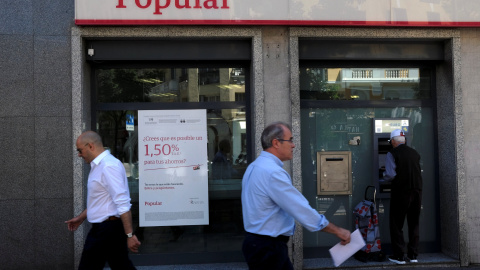 Varios transeuntes pasan junto a una oficina del Banco Popular en Madrid. REUTERS/Juan Medin