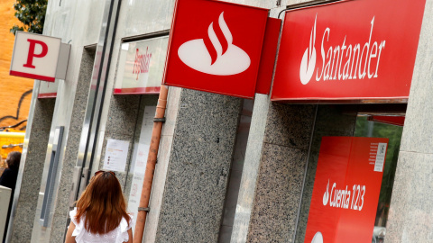 Una mujer pasa por delante de sendas sucursales de Banco Santander y Banco Popular en Barcelona. REUTERS/Albert Gea