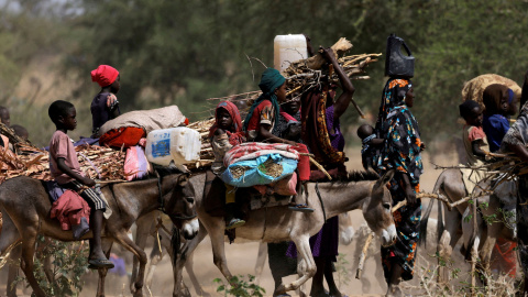 Los refugiados sudaneses que huyeron de la violencia en la región de Darfur en Sudán y los recién llegados montan en burros en busca de espacio para establecerse temporalmente, cerca de la frontera entre Sudán y Chad en Goungour, Chad, el 8 de mayo de