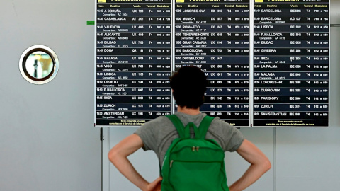 Un pasajero comprueba un panel de información sobre vuelos en la terminal 4 del aeropuerto Adolfo Suárez-Barajas en Madrid. EFE/ Victor Lerena/Archivo